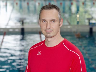 Stellvertretender Abteilungsleiter Roman Betker im roten T-Shirt. Im Hintergrund ein Schwimmbecken.