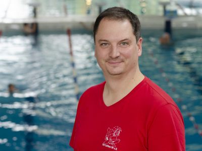 Abteilungsleiter Andreas Kretzschmar im roten T-Shirt. Im Hintergrund ein Schwimmbecken.