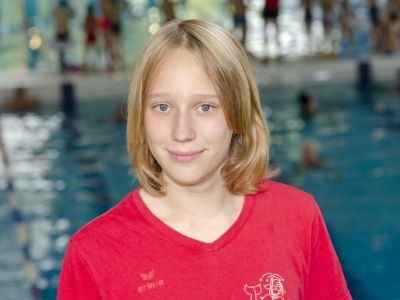 Trainerin Frida Gohr im roten Shirt. Im Hintergrund das Schwimmbecken.